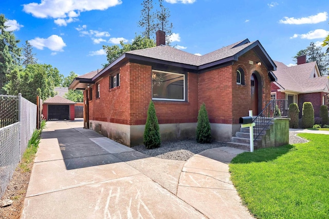 411 W 26th Ave, Spokane, WA 99203 - view of home's exterior featuring brick siding, a chimney, a garage, and an outbuilding