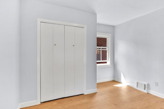 411 W 26th Ave, Spokane, WA 99203 - unfurnished bedroom with baseboards, light wood-style flooring, and a closet