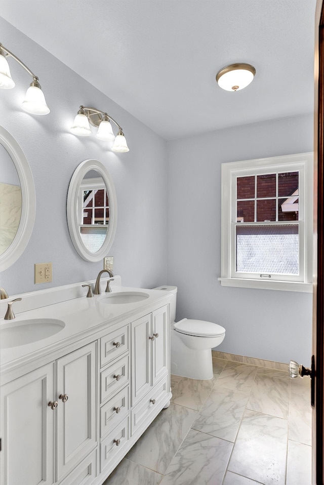 411 W 26th Ave, Spokane, WA 99203 - bathroom featuring double vanity, healthy amount of natural light, marble finish floors, and toilet