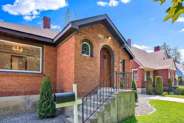 411 W 26th Ave, Spokane, WA 99203 - view of front of property featuring brick siding, a chimney, and a front yard