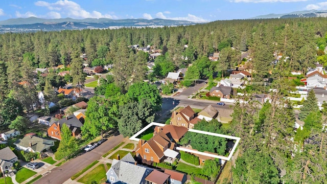 411 W 26th Ave, Spokane, WA 99203 - aerial view of property and surrounding area featuring a heavily wooded area, mountains, property parcel outlined, and nearby suburban area