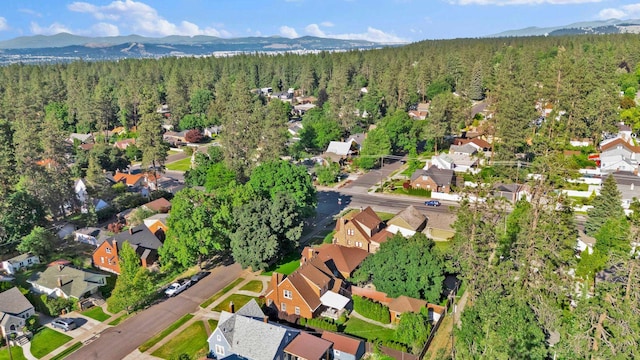 411 W 26th Ave, Spokane, WA 99203 - aerial overview of property's location featuring a heavily wooded area, a mountainous background, and nearby suburban area