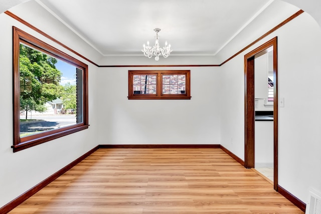 411 W 26th Ave, Spokane, WA 99203 - spare room featuring plenty of natural light, a chandelier, light wood-style flooring, and crown molding