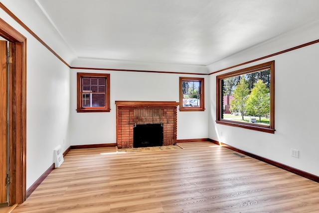 411 W 26th Ave, Spokane, WA 99203 - unfurnished living room with light wood-type flooring, baseboards, a fireplace, and crown molding