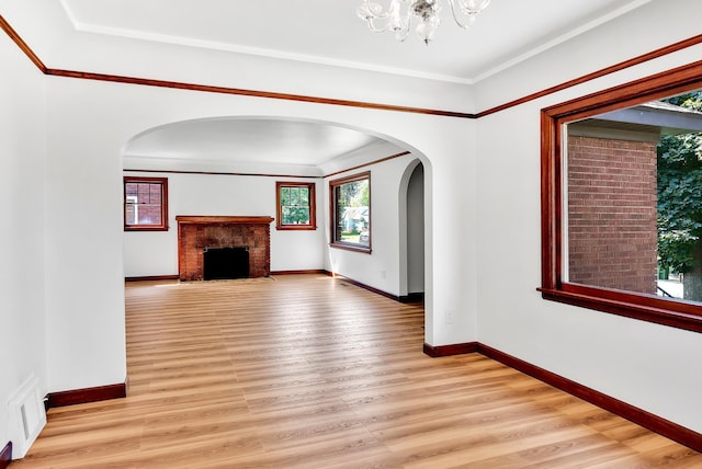 411 W 26th Ave, Spokane, WA 99203 - unfurnished living room featuring healthy amount of natural light, light wood-style flooring, arched walkways, and ornamental molding