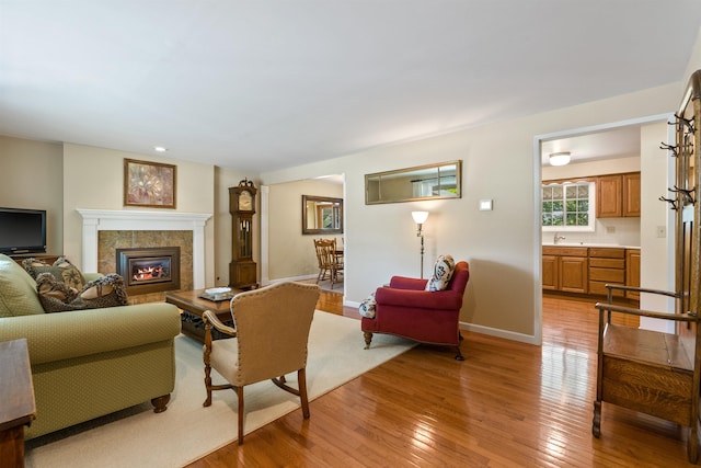 11605 N Merlin Dr, Spokane, WA 99218 - living room with light wood-style floors, a tile fireplace, and baseboards