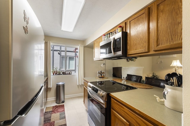 202 E Weile Ave Unit 2, Spokane, WA 99208 - kitchen with freestanding refrigerator, stainless steel microwave, electric stove, brown cabinets, and light countertops