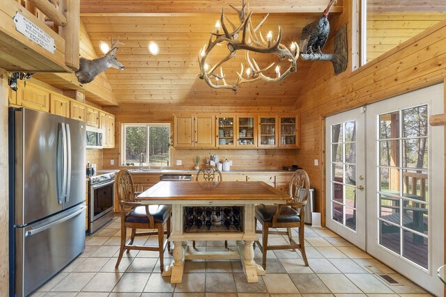 31579 E Hume Rd, Davenport, WA 99122 - dining area featuring wood ceiling, french doors, a chandelier, light tile patterned floors, and wooden walls