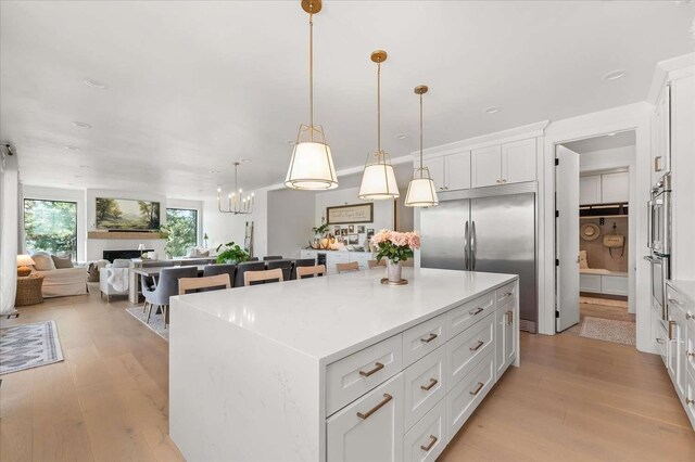 9610 S Mullen Hill Rd, Spokane, WA 99224 - kitchen with stainless steel built in fridge, white cabinets, light wood-style floors, a center island, and open floor plan