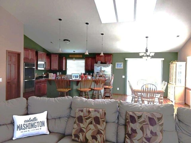 633C Garvey Rd, Colville, WA 99114 - living room with lofted ceiling, light wood-style floors, and a chandelier