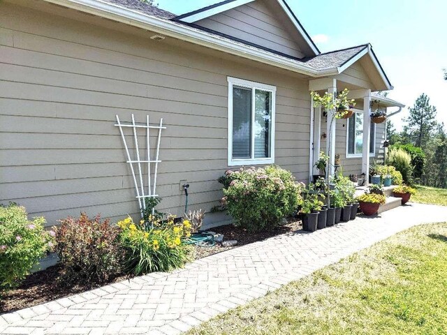 633C Garvey Rd, Colville, WA 99114 - view of side of home featuring roof with shingles and a yard