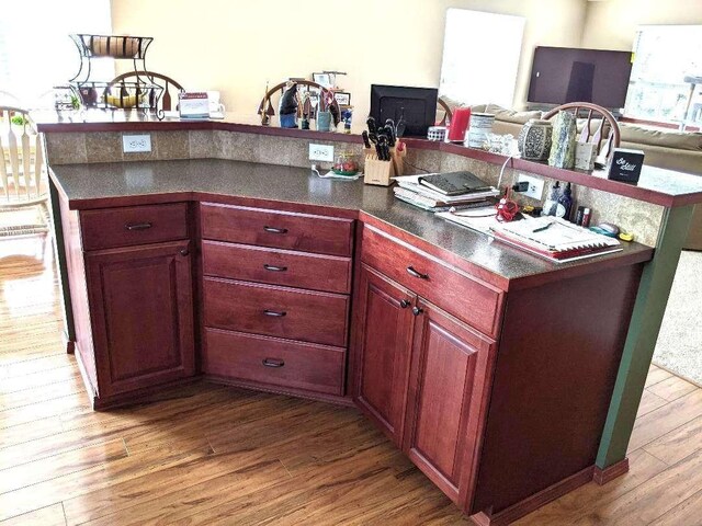633C Garvey Rd, Colville, WA 99114 - kitchen with wood finished floors, reddish brown cabinets, open floor plan, and dark countertops