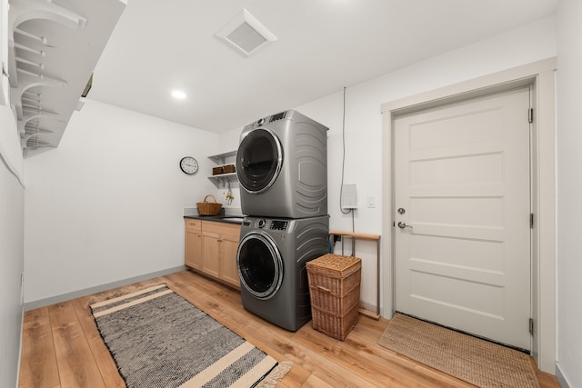 16106 N Mt Spokane Park Dr, Mead, WA 99021 - laundry room with stacked washer and clothes dryer, cabinet space, light wood-style flooring, recessed lighting, and baseboards