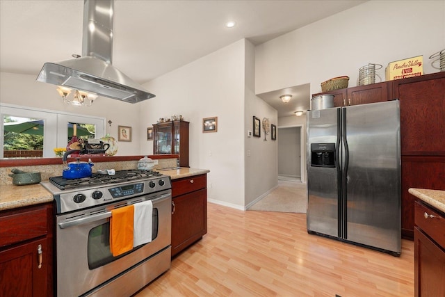 813 Tamarack Ln, Chewelah, WA 99109 - kitchen featuring appliances with stainless steel finishes, island exhaust hood, lofted ceiling, light countertops, and light wood-type flooring