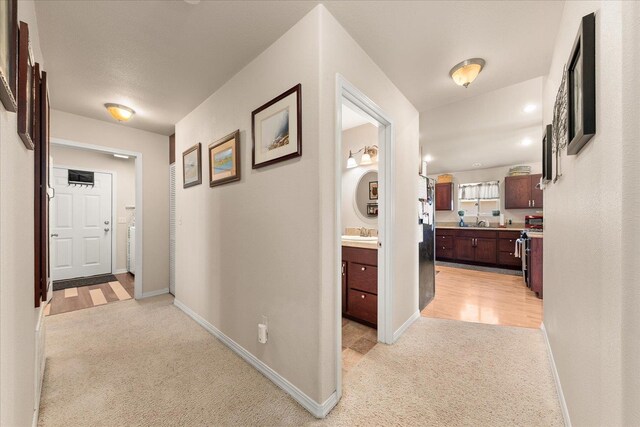 813 Tamarack Ln, Chewelah, WA 99109 - corridor with light carpet, baseboards, and a sink