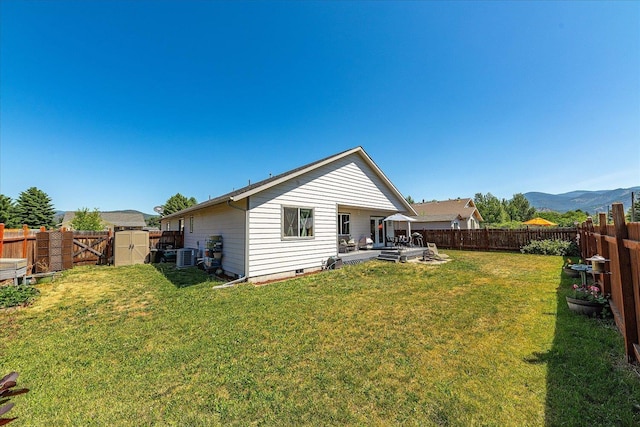813 Tamarack Ln, Chewelah, WA 99109 - back of property with central air condition unit, a mountain view, crawl space, and a shed