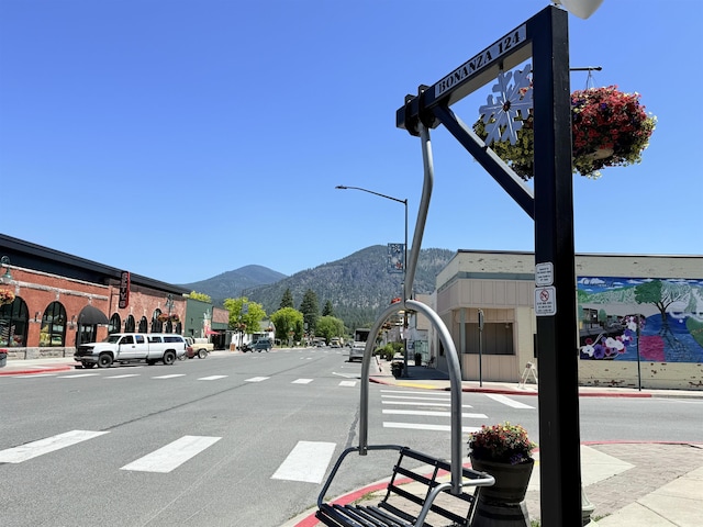 813 Tamarack Ln, Chewelah, WA 99109 - view of asphalt street with a mountain view, sidewalks, curbs, street lighting, and traffic signs