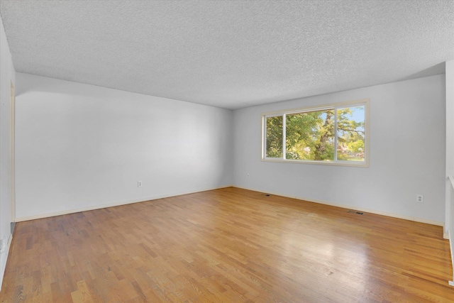 1517 E Olympic Ave, Spokane, WA 99207 - empty room with light wood finished floors, a textured ceiling, and baseboards