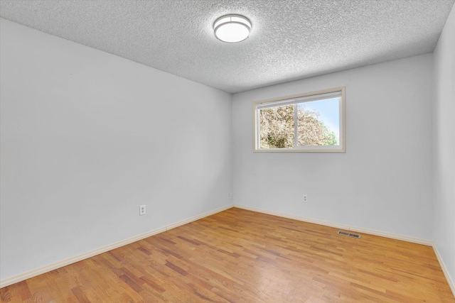 1517 E Olympic Ave, Spokane, WA 99207 - empty room featuring wood finished floors, a textured ceiling, and baseboards