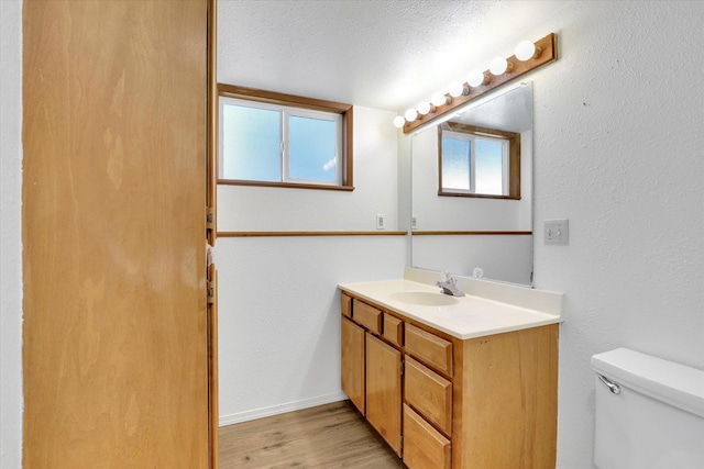 1517 E Olympic Ave, Spokane, WA 99207 - bathroom with vanity, toilet, wood finished floors, and baseboards