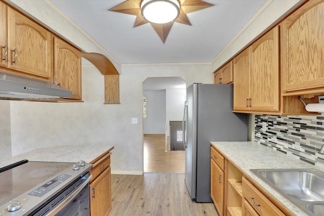 1517 E Olympic Ave, Spokane, WA 99207 - kitchen featuring appliances with stainless steel finishes, under cabinet range hood, arched walkways, tasteful backsplash, and light countertops