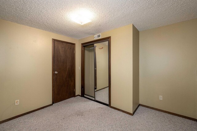 24615 E Joseph Ave, Otis Orchards, WA 99027 - unfurnished bedroom with light colored carpet, a textured ceiling, a closet, and baseboards