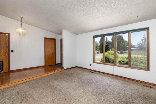 24615 E Joseph Ave, Otis Orchards, WA 99027 - unfurnished room with lofted ceiling, a chandelier, carpet, a textured ceiling, and baseboards
