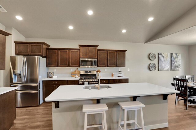 18381 E 17th Ave, Greenacres, WA 99016 - kitchen with appliances with stainless steel finishes, light wood-style flooring, light countertops, a breakfast bar area, and recessed lighting