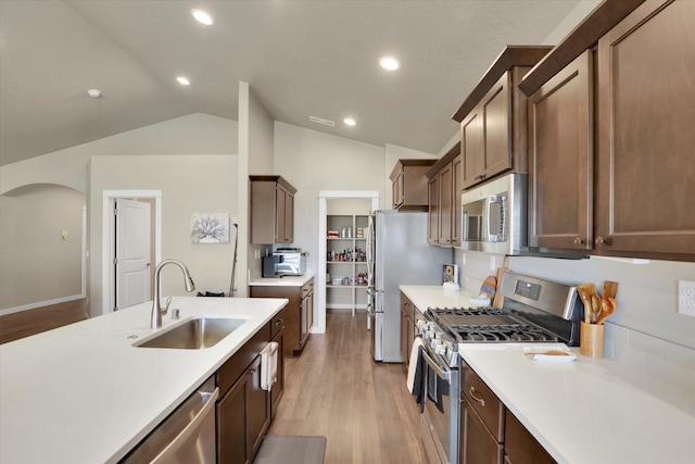 18381 E 17th Ave, Greenacres, WA 99016 - kitchen with stainless steel appliances, light wood-style flooring, light countertops, lofted ceiling, and arched walkways