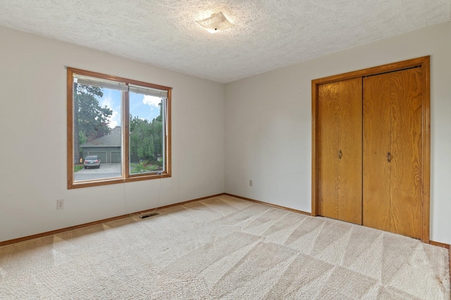 1621 E 65th Ave, Spokane, WA 99223 - unfurnished bedroom with a closet, a textured ceiling, and light colored carpet