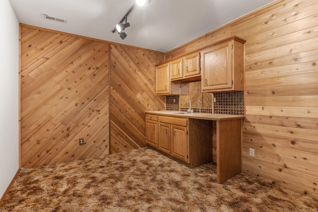 1621 E 65th Ave, Spokane, WA 99223 - kitchen featuring carpet floors, wood walls, light brown cabinets, light countertops, and rail lighting