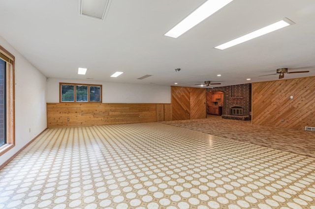1621 E 65th Ave, Spokane, WA 99223 - unfurnished living room featuring wooden walls, ceiling fan, and a fireplace