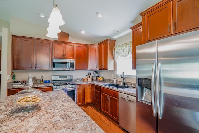 38823 N Newport Hwy, Elk, WA 99009 - kitchen featuring stainless steel appliances, light wood-style flooring, vaulted ceiling, light stone counters, and hanging light fixtures