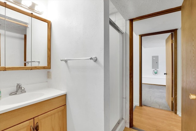 4717 S Skipworth Rd, Spokane Valley, WA 99206 - full bath featuring vanity, a shower stall, wood finished floors, electric panel, and a textured ceiling