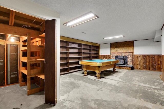 4717 S Skipworth Rd, Spokane Valley, WA 99206 - game room featuring a wood stove, wood walls, pool table, unfinished concrete floors, and a wainscoted wall