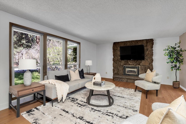 4717 S Skipworth Rd, Spokane Valley, WA 99206 - living area featuring a stone fireplace, wood finished floors, and a textured ceiling