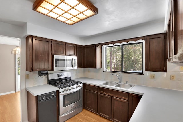 4717 S Skipworth Rd, Spokane Valley, WA 99206 - kitchen featuring stainless steel appliances, tasteful backsplash, light countertops, light wood-type flooring, and dark brown cabinetry
