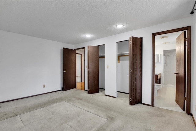 4717 S Skipworth Rd, Spokane Valley, WA 99206 - unfurnished bedroom with light colored carpet, a textured ceiling, two closets, ensuite bath, and recessed lighting