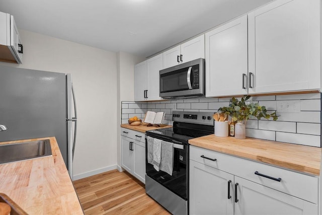 1501 N Lily Rd, Spokane, WA 99212 - kitchen with stainless steel appliances, wood counters, light wood finished floors, and backsplash