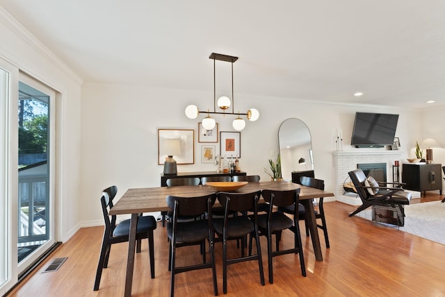 4118 S Stone St, Spokane, WA 99223 - dining room featuring light wood-type flooring, a brick fireplace, ornamental molding, and recessed lighting