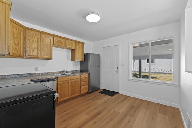 3927 E Fairview Ave, Spokane, WA 99217 - kitchen featuring stainless steel appliances, light wood-style floors, dark countertops, and brown cabinets