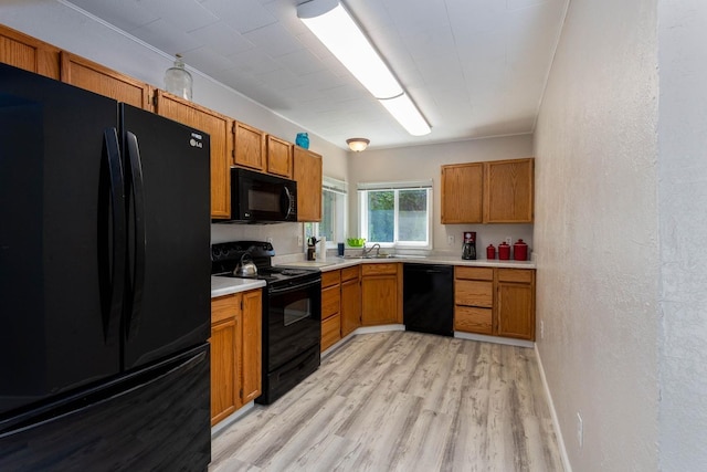 337 Lehigh Hill Rd, Metaline Falls, WA 99153 - kitchen with black appliances, light wood-type flooring, light countertops, brown cabinetry, and a textured wall