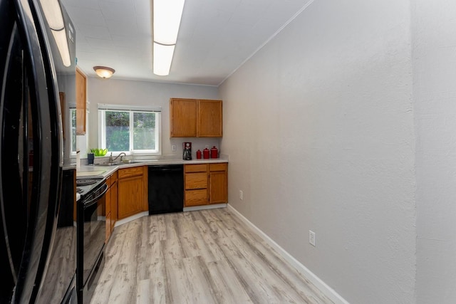 337 Lehigh Hill Rd, Metaline Falls, WA 99153 - kitchen featuring black appliances, light countertops, brown cabinetry, light wood-style flooring, and crown molding