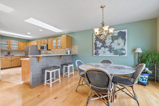 7802 E Timber Ridge Ln, Spokane Valley, WA 99212 - dining room featuring light wood-style flooring, a chandelier, recessed lighting, and a skylight