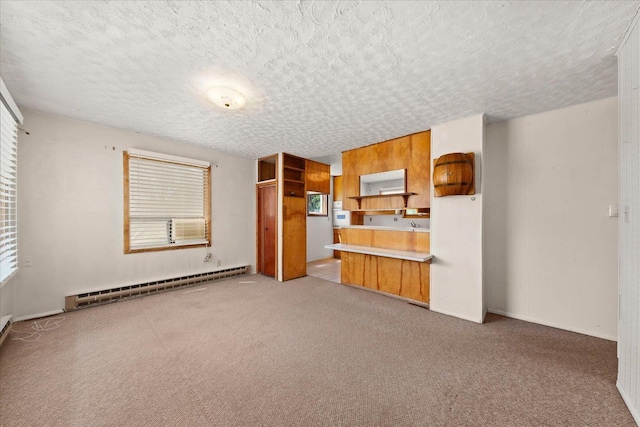 10904 E 26th Ave, Spokane, WA 99206 - unfurnished living room with a baseboard radiator, a textured ceiling, light colored carpet, and healthy amount of natural light