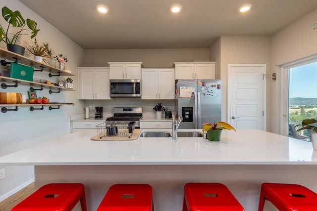 5414 E Bridgeport Ct, Spokane, WA 99217 - kitchen with appliances with stainless steel finishes, a center island with sink, white cabinetry, light countertops, and recessed lighting