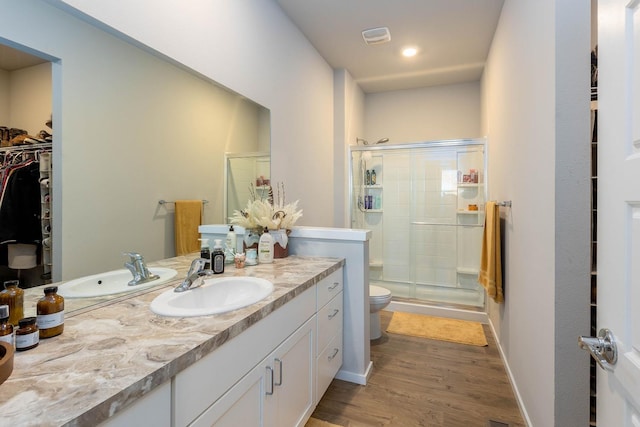 5414 E Bridgeport Ct, Spokane, WA 99217 - bathroom featuring a shower stall, vanity, wood finished floors, and a walk in closet