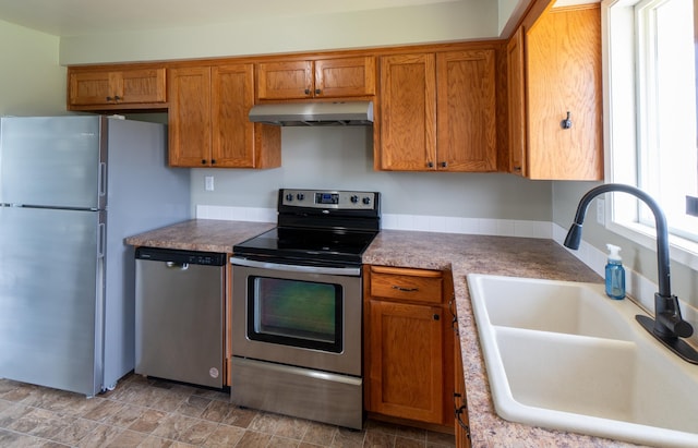 4806 N Drury Rd, Otis Orchards, WA 99027 - kitchen with appliances with stainless steel finishes, exhaust hood, brown cabinets, and light countertops