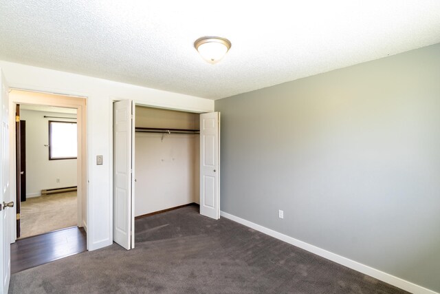 4806 N Drury Rd, Otis Orchards, WA 99027 - unfurnished bedroom featuring dark colored carpet, a closet, a baseboard radiator, and a textured ceiling