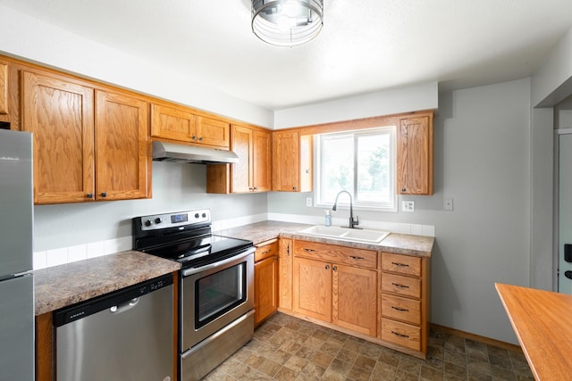 4806 N Drury Rd, Otis Orchards, WA 99027 - kitchen with appliances with stainless steel finishes, under cabinet range hood, light countertops, and stone finish floors